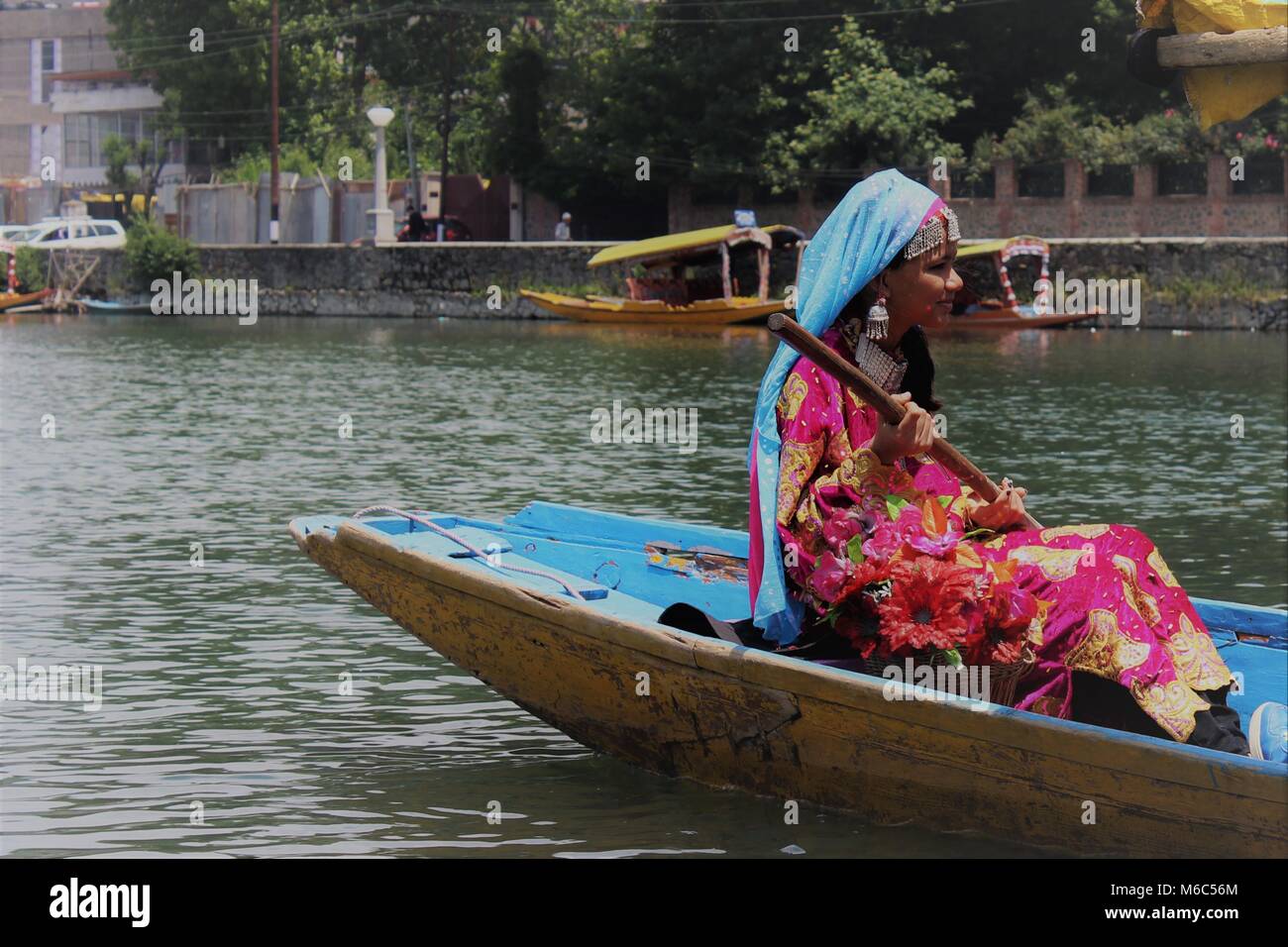 Matin voir de Dal Lake, à Srinagar, au Cachemire, en Inde. Une fille d'un bateau d'aviron dans une tenue traditionnelle de l'Inde. Banque D'Images