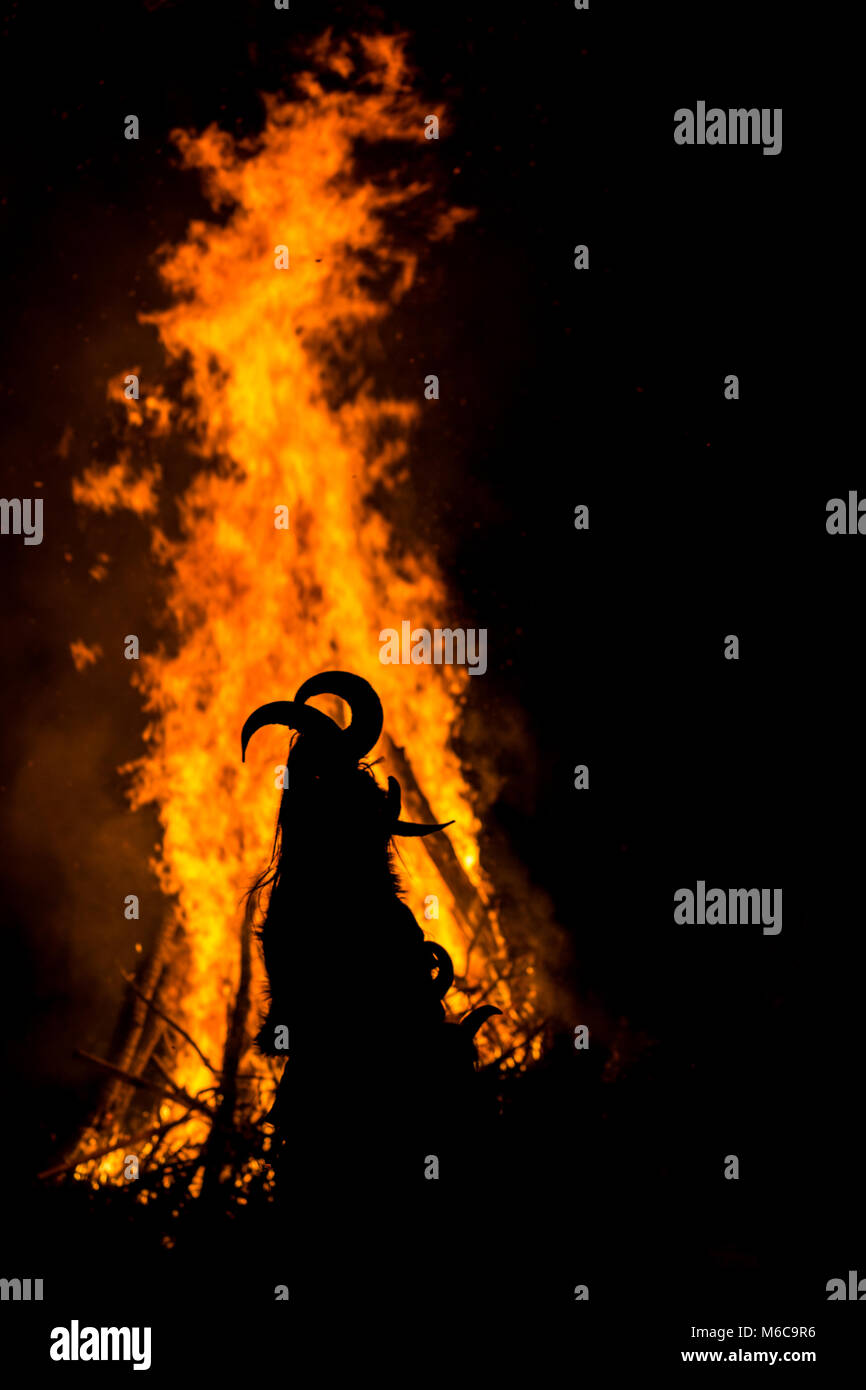 Danse autour de l'immense flamme rituelle en masque à cornes Banque D'Images