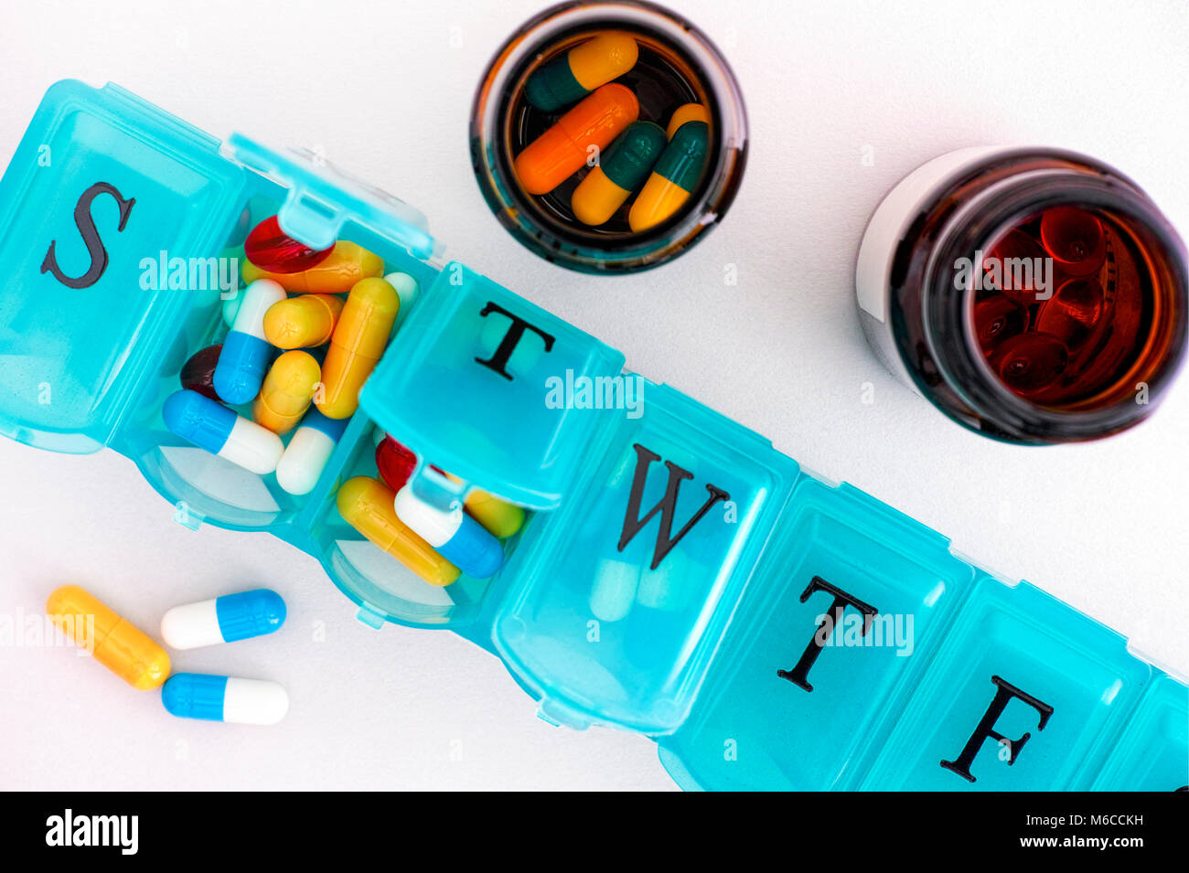 Comprimé organiseur avec pills et bouteilles sur fond blanc. Close-up. Banque D'Images