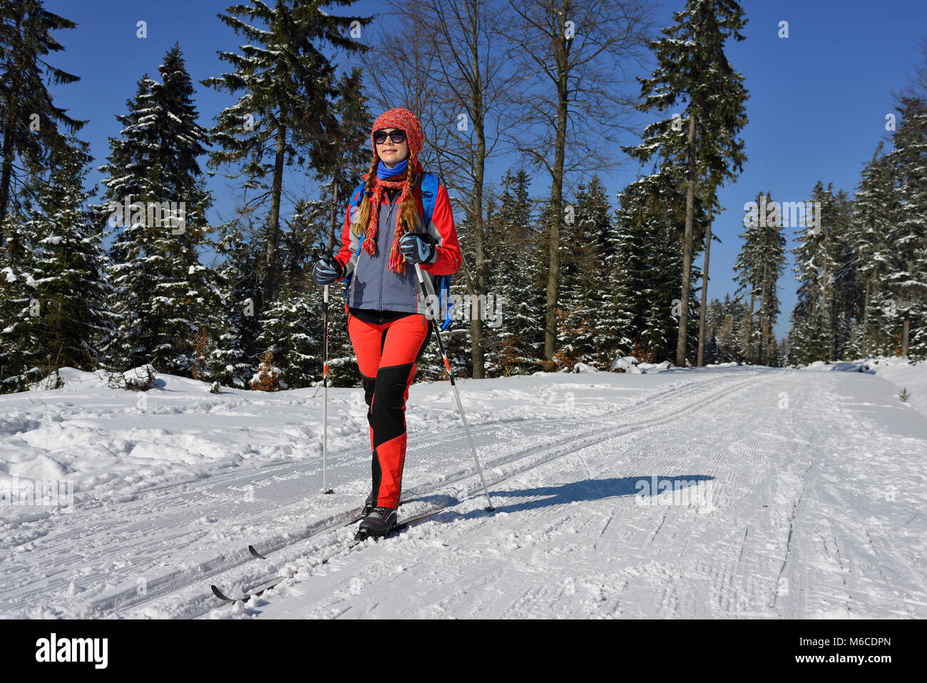 Femme à la Robe de couleur sur des skis de fond entre les arbres traités avec la neige en montagne en Pologne Banque D'Images