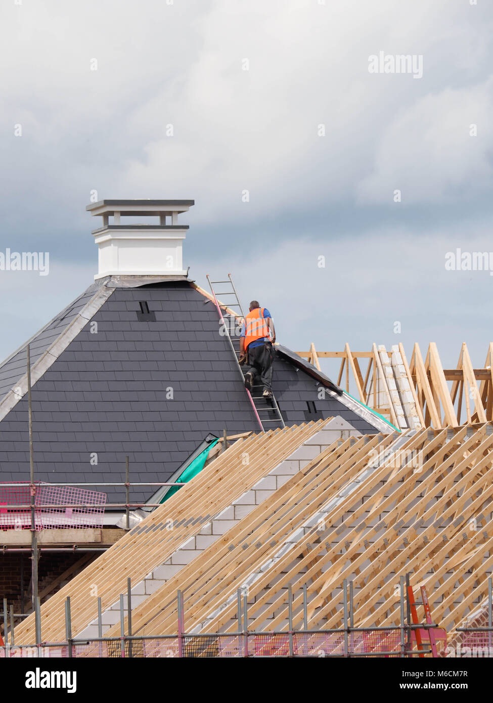 Carreleur TOIT TRAVAILLANT SUR UN CHANTIER DE CONSTRUCTION DE NOUVELLES MAISONS EN CONSTRUCTION POUR HOPKINS, NORFOLK STALHAM Banque D'Images