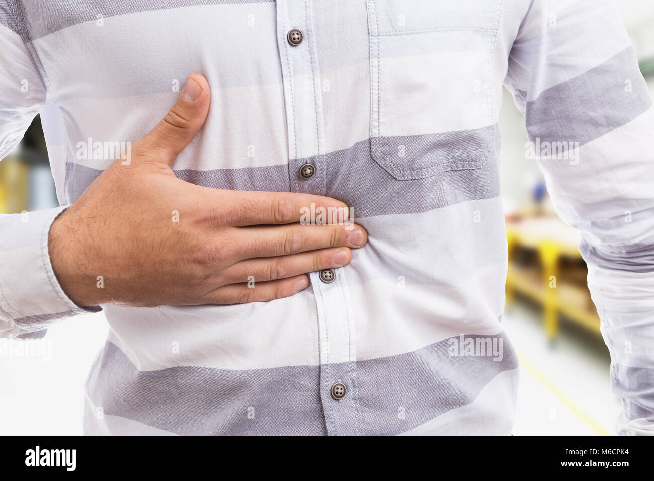 Concept d'acide gastrique avec l'homme en appuyant sur son estomac et l'indigestion aussi problème au travail Banque D'Images