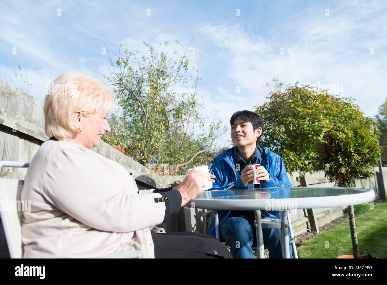 Un logement étudiant avec son siège d'accueil des étudiants internationaux dans le jardin de boire du thé et parler. Banque D'Images