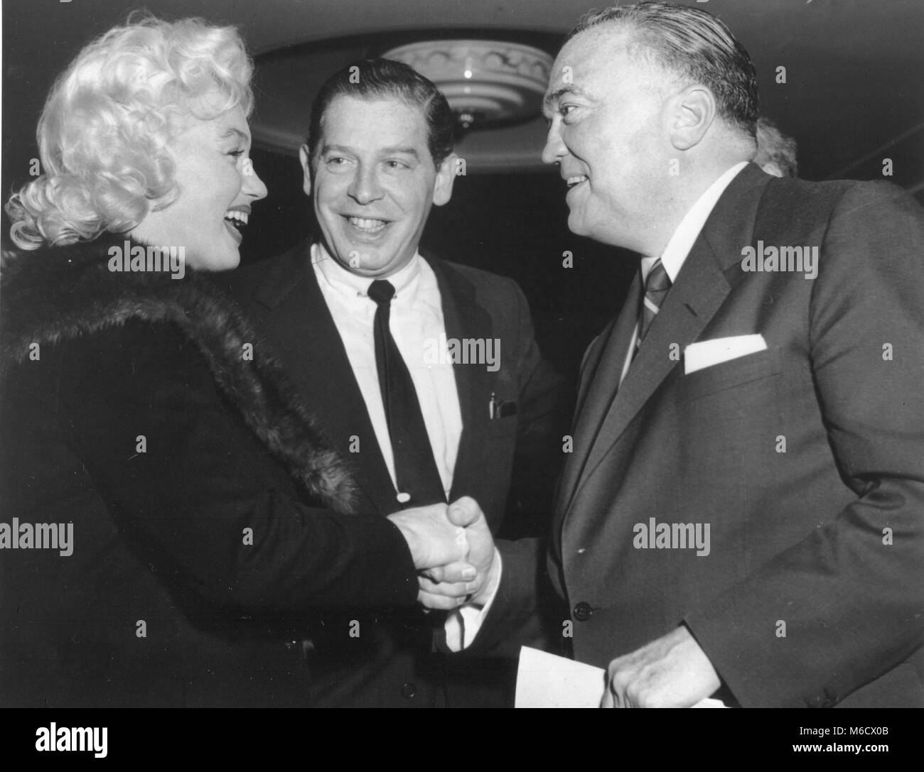L'actrice Marilyn Monroe et star de la télévision Milton Berle saluer le Directeur du FBI J. Edgar Hoover à Banshee, déjeuner à l'Hôtel Waldorf-Astoria. New York, NY, 26/4/1955, Banque D'Images