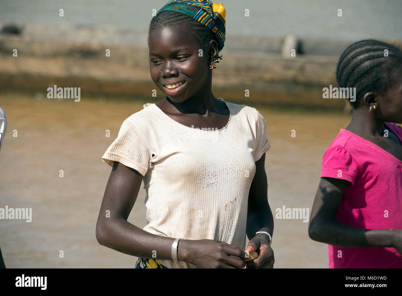 Une jeune adolescente autochtones, ethniques, tribales, fille Bozo souriant, portant un t-shirt. Le Mali, Afrique de l'Ouest. Banque D'Images