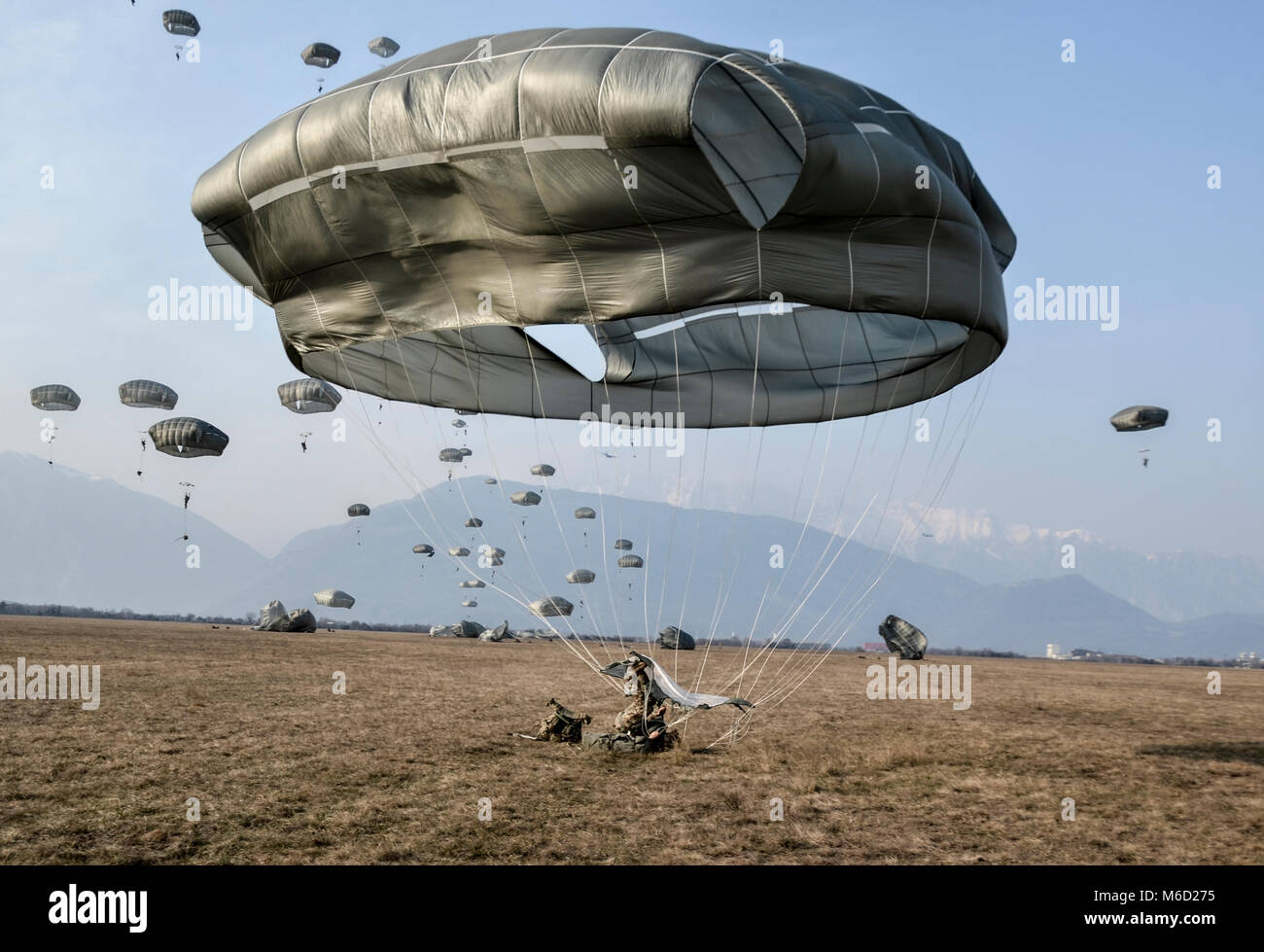 Un parachutiste effectue un atterrissage en parachute sur le sol comme la 173e Brigade aéroportée effectue un assaut aéroporté dans le nord de l'Italie. Banque D'Images