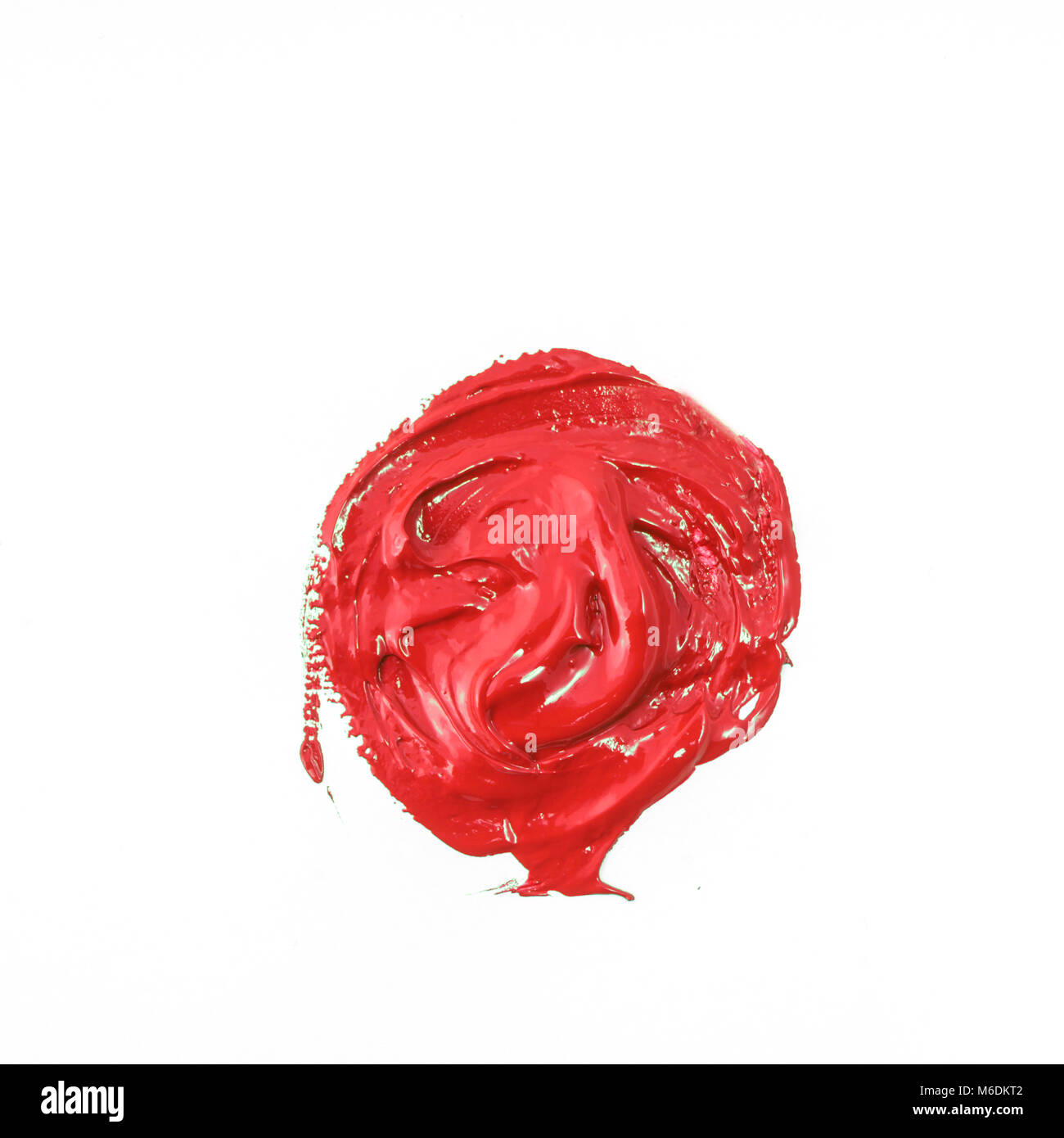 Une goutte de couleur rouge acrylique sur une surface blanche Banque D'Images
