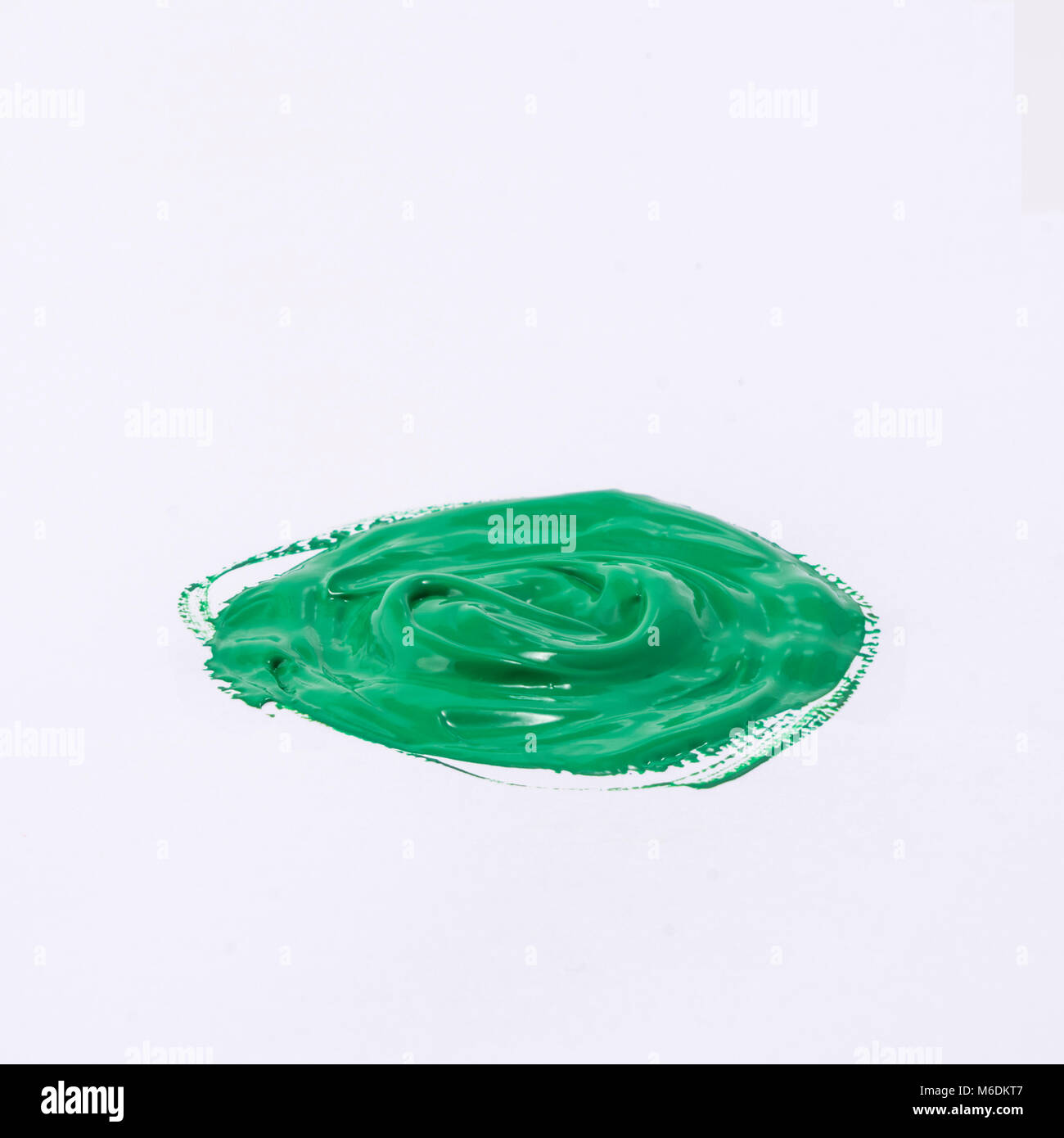 Une goutte de peinture acrylique couleur vert sur une surface blanche Banque D'Images