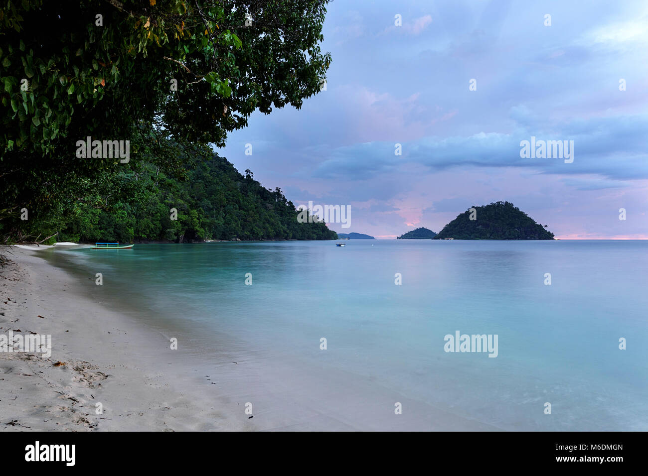 Belle plage de sable au coucher du soleil tropical avec des tons roses Banque D'Images