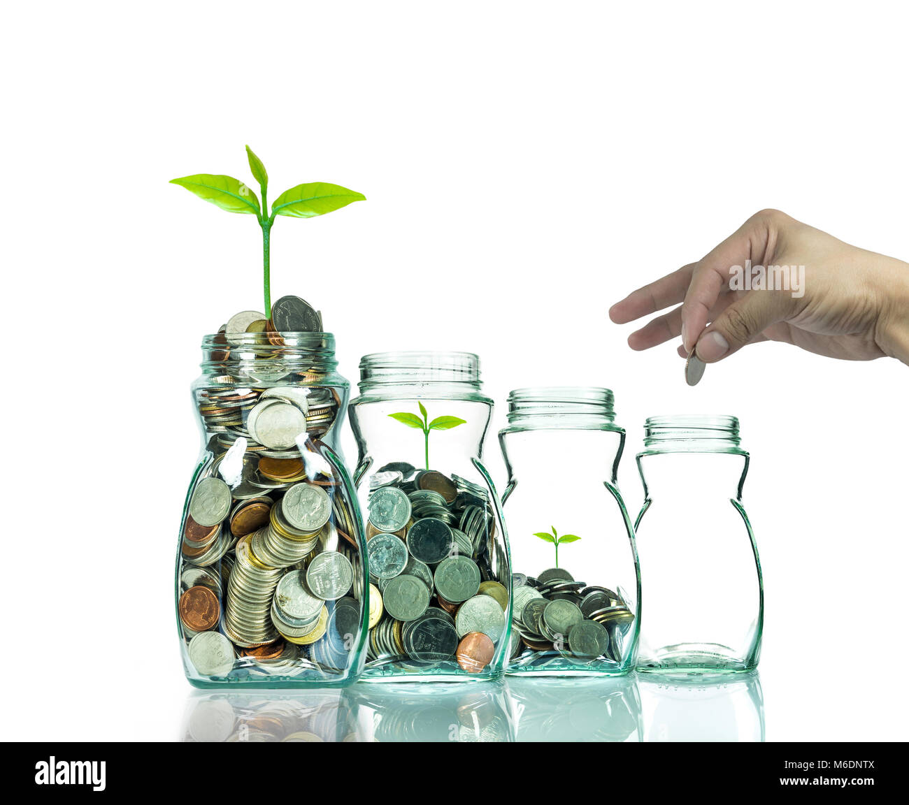 Mettre la main pièces mix et de semences en bouteille transparente sur fond blanc,la croissance d'un placement d'entreprise concept Banque D'Images