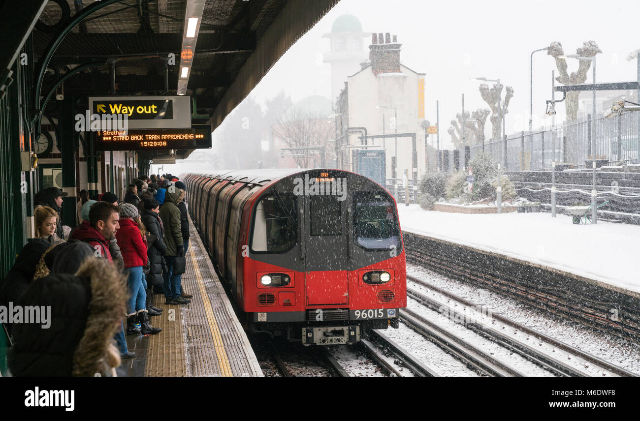 2 mars 2018 - Londres, Angleterre. Personnes en attente d'un train à l'approche du Jubilé de la plate-forme. Beaucoup de neige et il fait froid à Londres. Banque D'Images