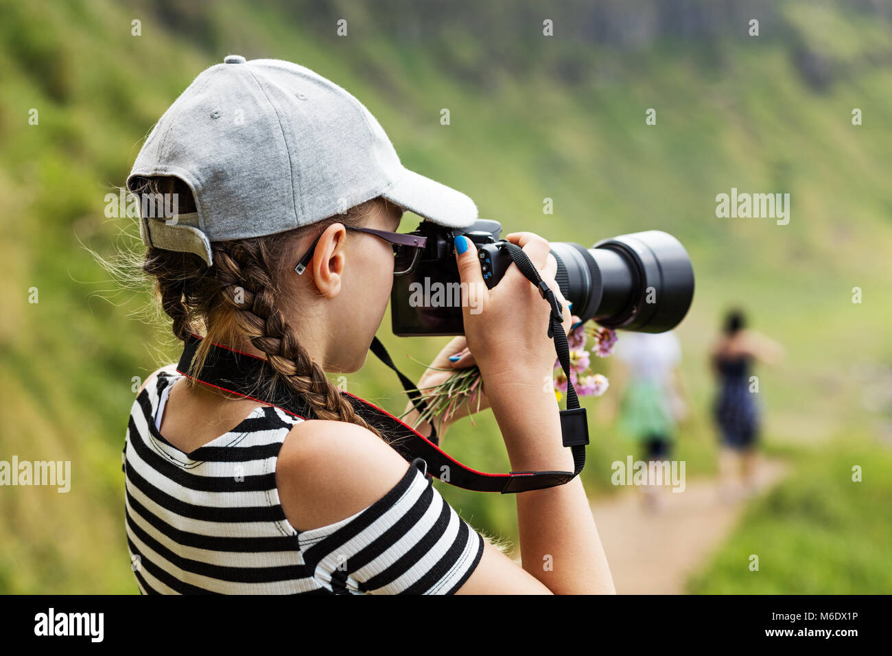 12 ans, fille, et prendre des photos avec un objectif long dans un magnifique paysage de falaises irlandaises Banque D'Images