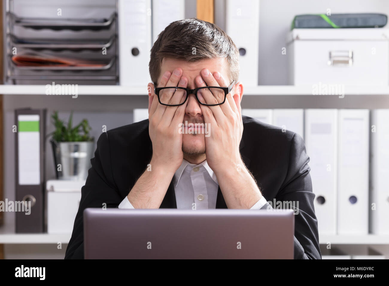 Close-up of a Young Businessman Sitting fatigué In Office Banque D'Images