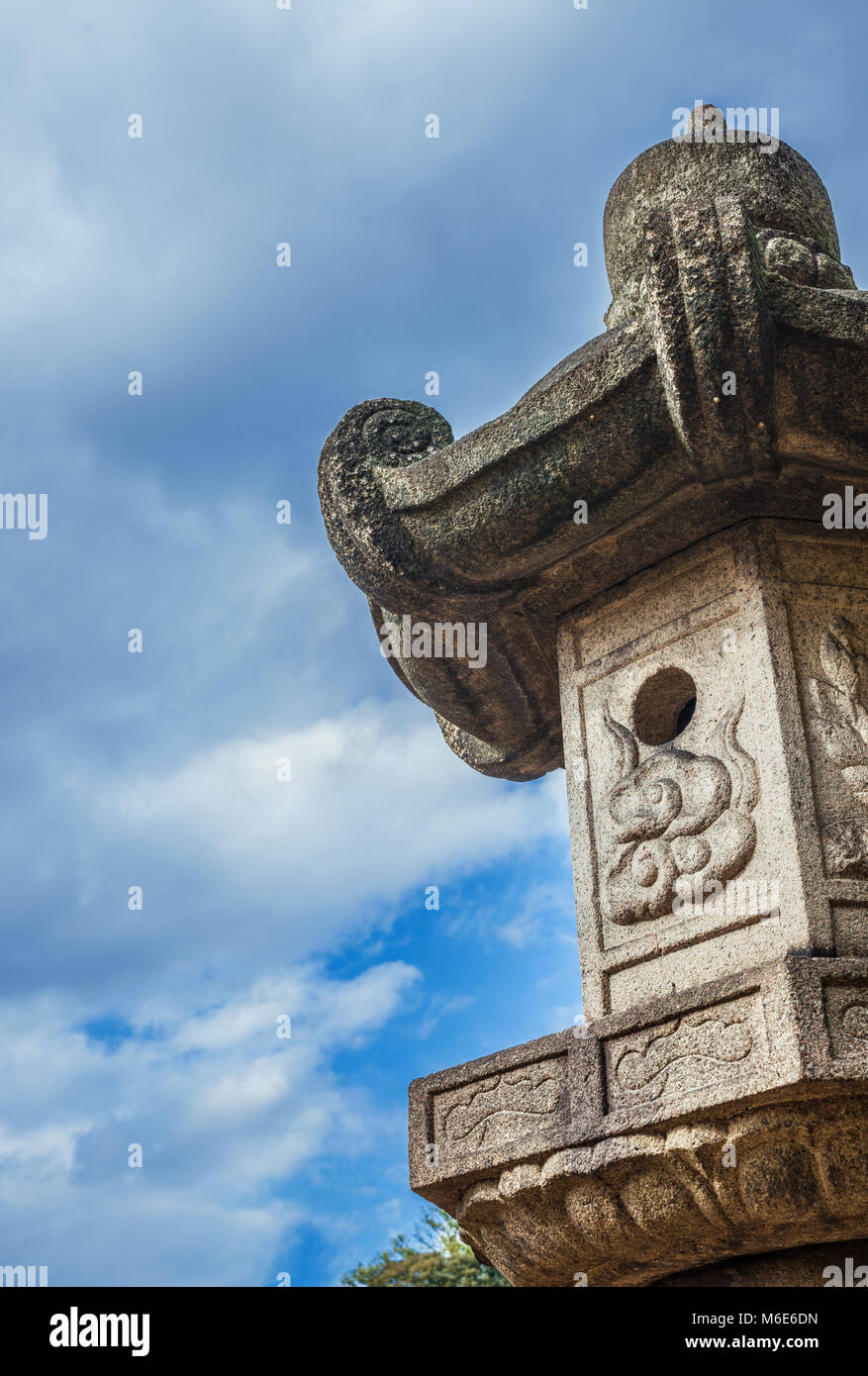 La lanterne de pierre japonais traditionnel ancien, un type se trouvent souvent dans des jardins (avec des nuages et de l'espace de copie) Banque D'Images