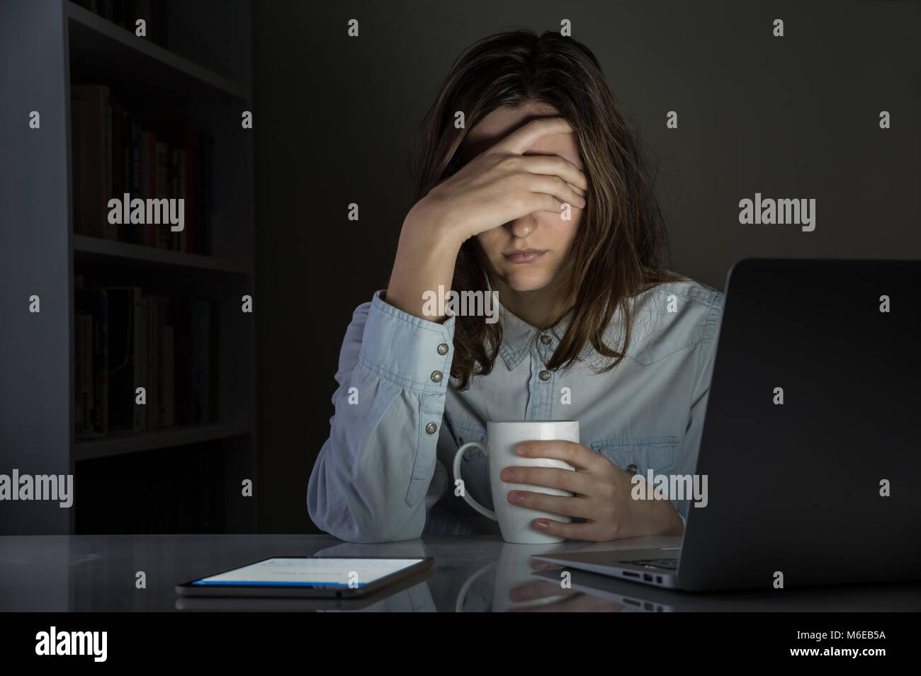 Fatigué et déçu personne de sexe féminin à la maison tard dans la nuit au travail de bureau Banque D'Images