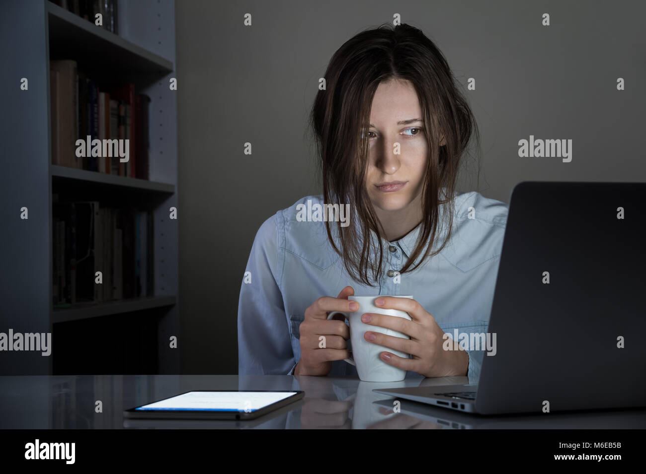 Fatigué sleepy personne de sexe féminin avec tasse de café de travail Banque D'Images