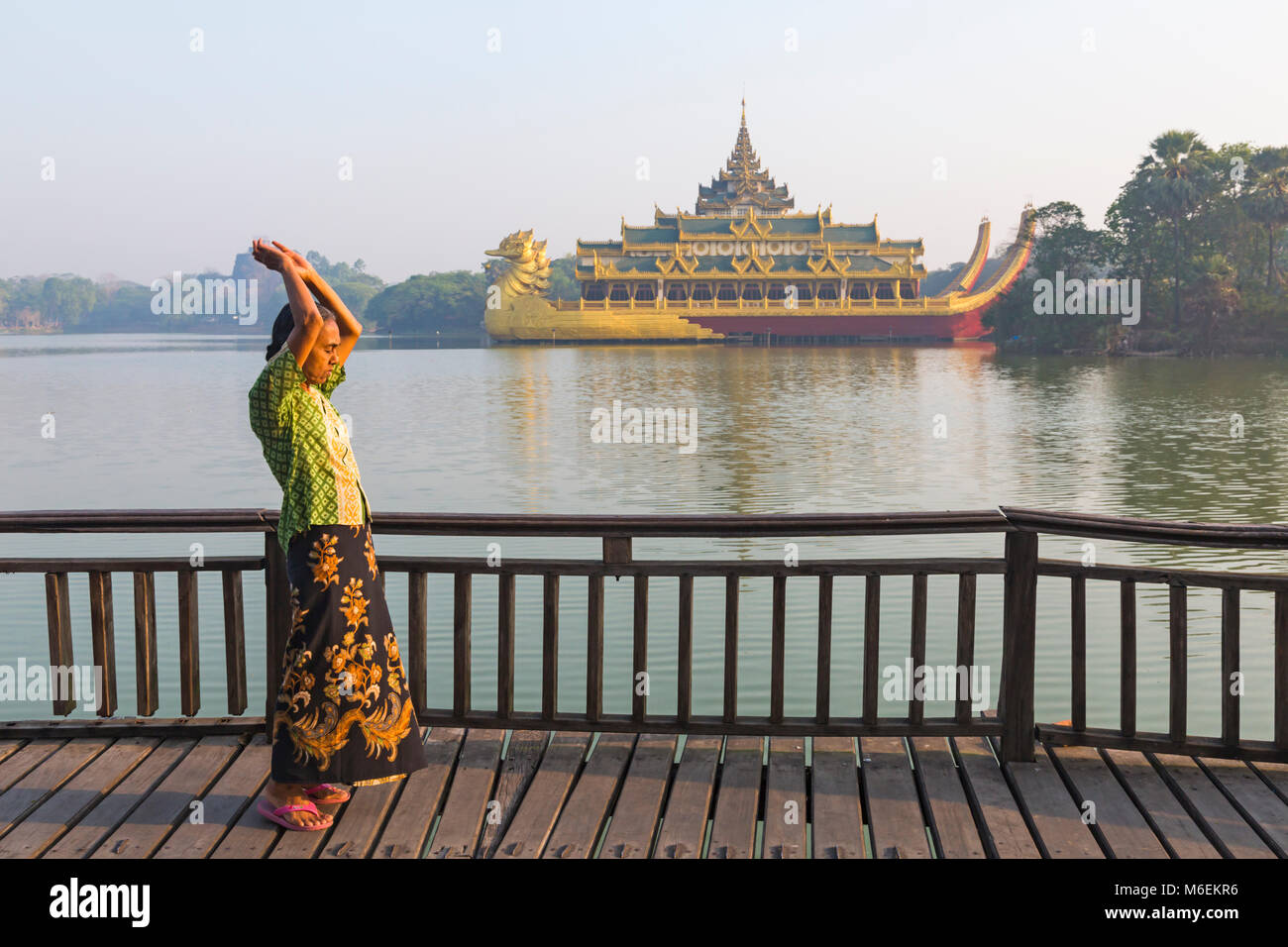 Femme birmane exercices tôt le matin par barge royale, Palais Karaweik, Yangon, Myanmar (Birmanie), l'Asie en février Banque D'Images