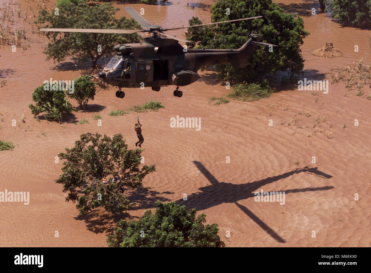 Inondations au Mozambique, mars 2000 ; un hélicoptère de l'Armée de l'air sud-africaine porte secours à personnes en détresse des toits près de Chibuto, province de Gaza. Banque D'Images