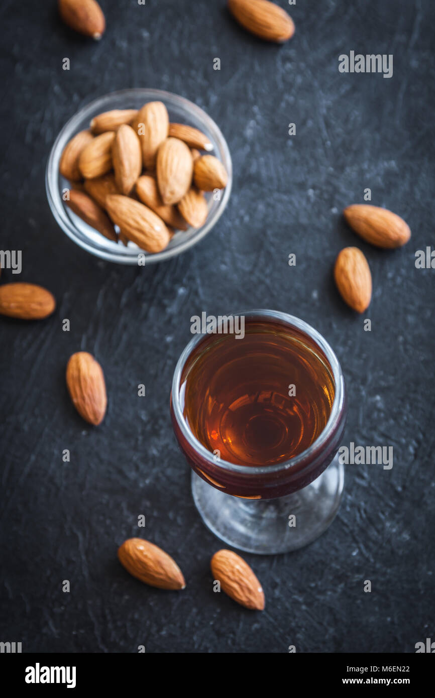 Amaretto Liqueur italienne aux amandes sur fond noir en noir, copy space Banque D'Images