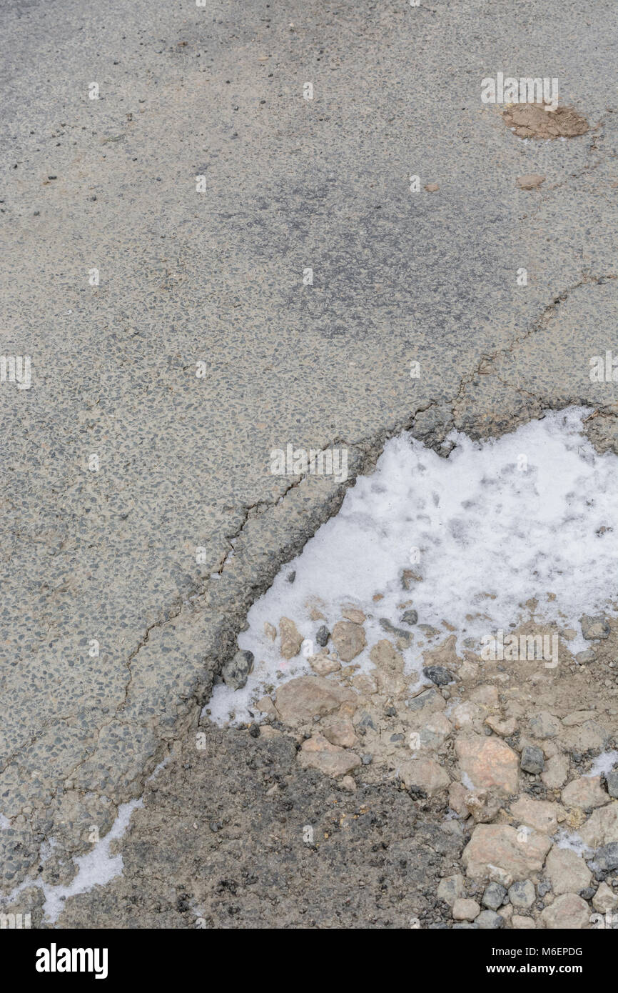 La surface de la route endommagée forst pauvres avec la pénétration de nouveaux neige de l'hiver. Banque D'Images