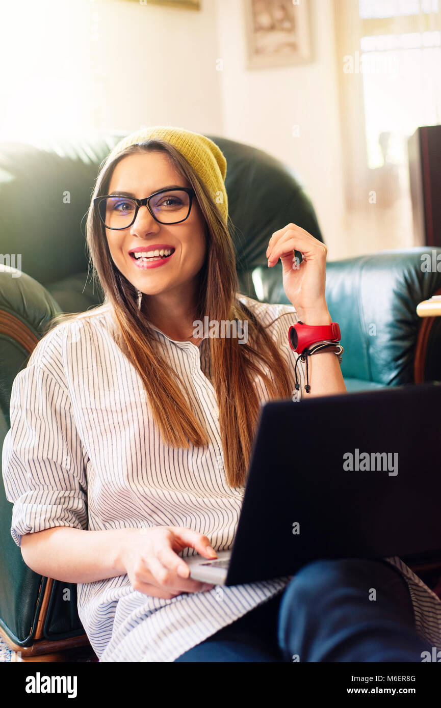Hipster femme assise sur le sol à l'aide d'un ordinateur portable Banque D'Images