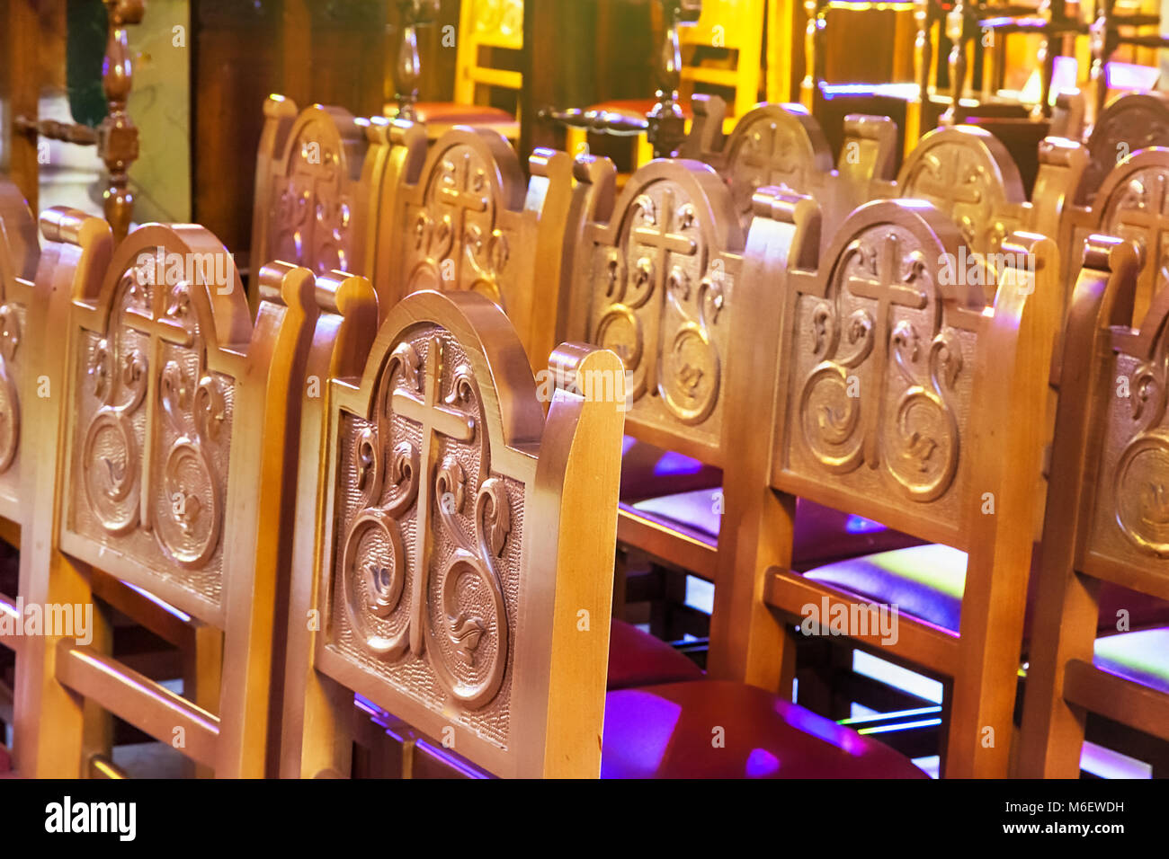 Des chaises dans l'église d'une ligne dans une cathédrale orthodoxe grecque . Sculpture sur bois ajouré de meubles. Banque D'Images