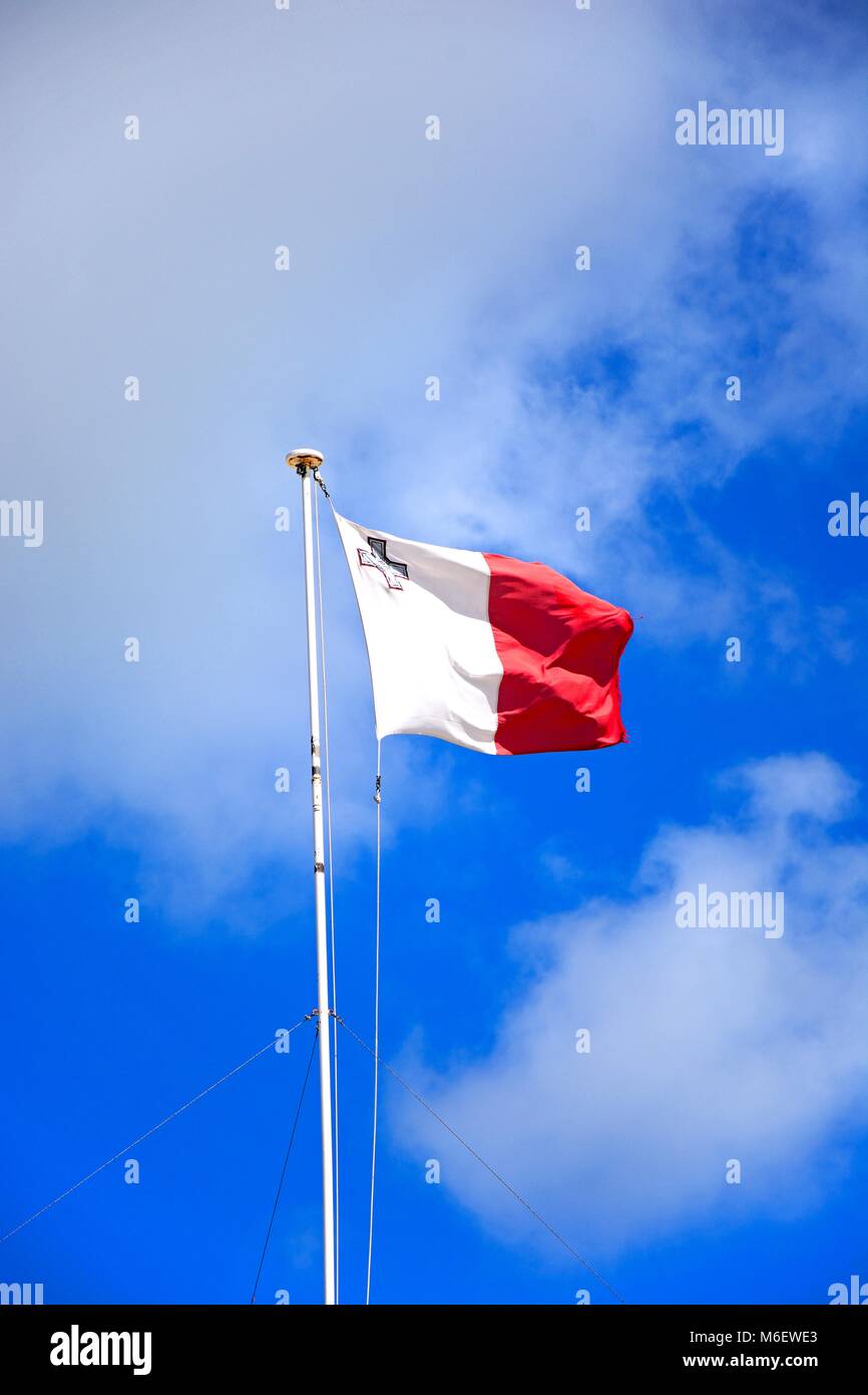 Pavillon maltais ont déroulé contre un ciel bleu avec des nuages, Gozo, Malte. Banque D'Images