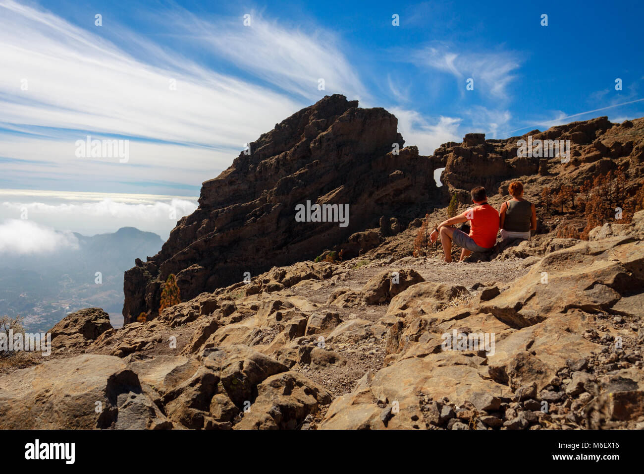 Deux touristes d'âge mûr assis sur les montagnes rocheuses de l'île de Gran Canaria. Banque D'Images