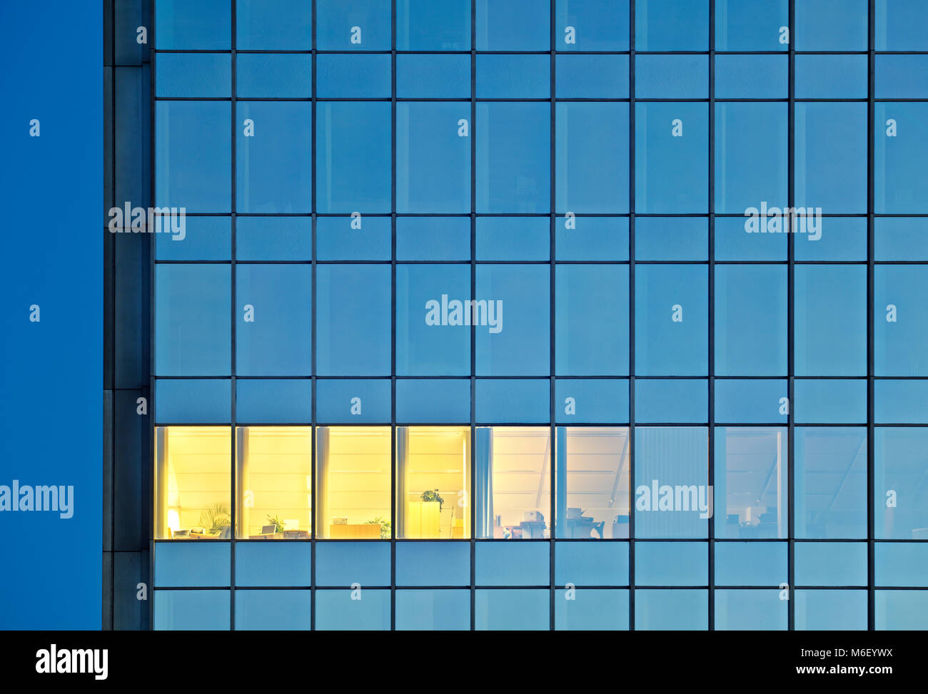 Une seule fenêtre de bureau lumineux dans un bâtiment moderne en verre et acier bank building. Fin de travail dans une tour à bureaux. Banque D'Images