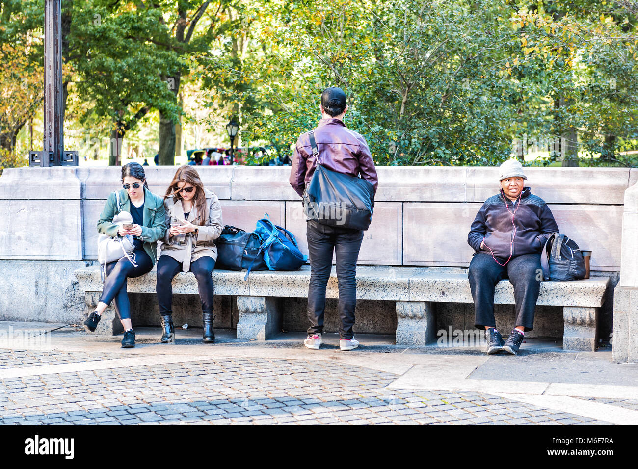 La ville de New York, USA - 28 octobre 2017 : Manhattan avec des gens assis sur des bancs par Columbus Circle, Central Park sur entrée libre journée ensoleillée Banque D'Images