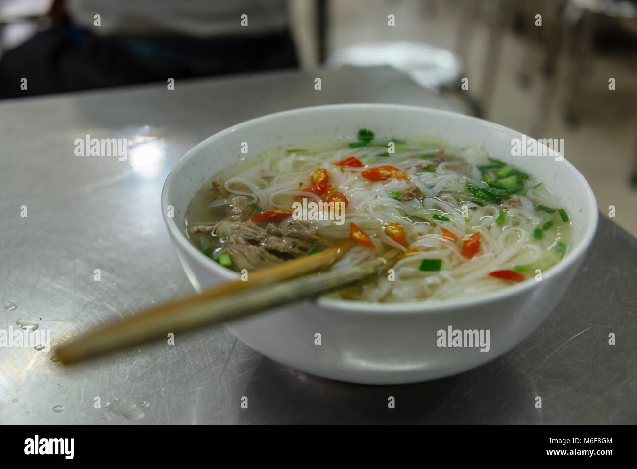 Un bol de soupe au poulet et nouilles au petit-déjeuner dans un restaurant à Hanoi, Vietnam Banque D'Images