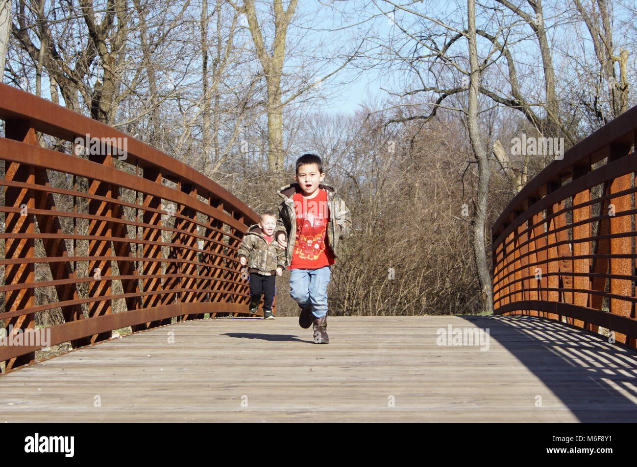 Deux enfants qui courent sur le pont à Hedges Boyer Park à Tiffin, en Ohio. Banque D'Images