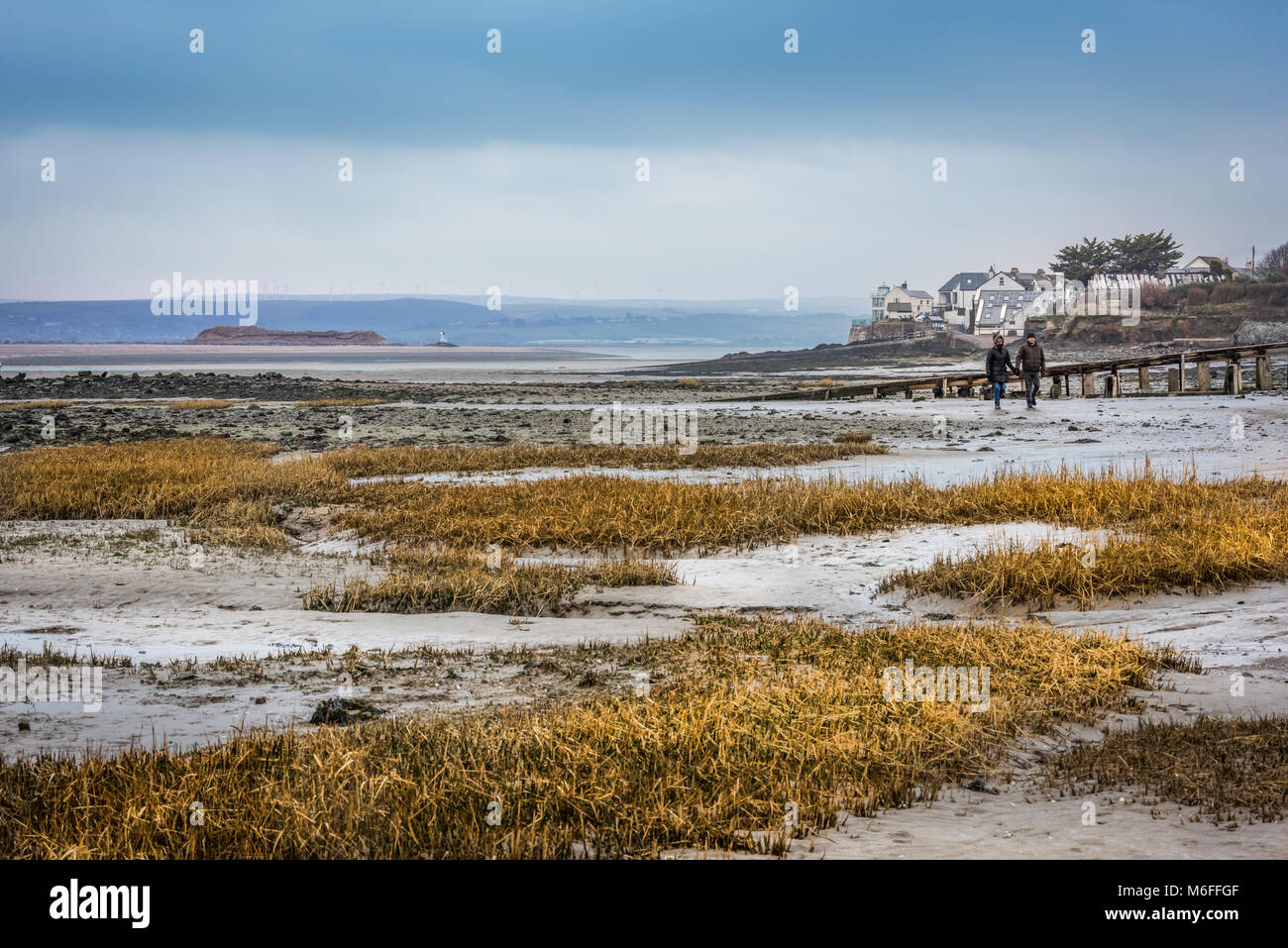 UK - avec la température, proches de zéro, la neige remplace la pluie, en couple profitez d'une promenade vivifiante sur le sentier du littoral d'Appledore à Northam Burrows dans le Nord du Devon. Banque D'Images