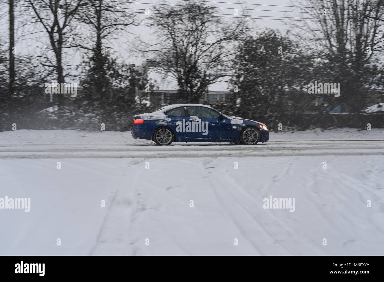 Une BMW série 3 bleu le long des lecteurs un couvert de neige36 vers Southampton dans des conditions de conduite. Banque D'Images