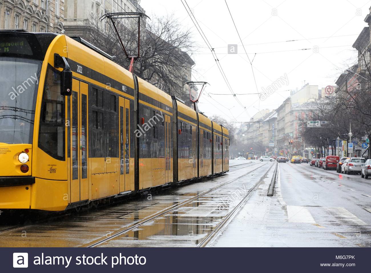 Un tramway de Budapest jaune se trouve dans la pluie en attente d'extraire par une froide journée d'hiver en Hongrie Banque D'Images