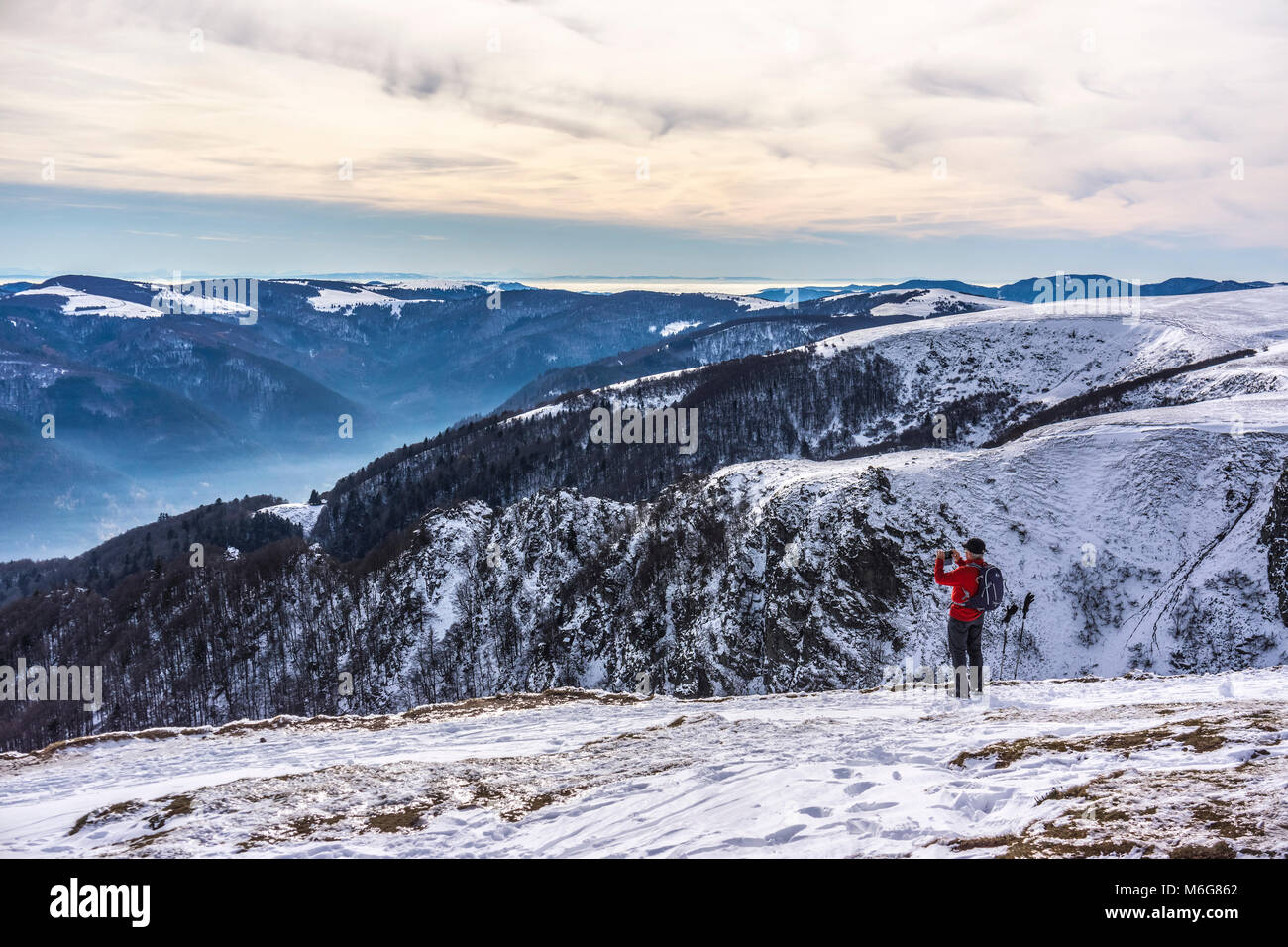 Un randonneur de prendre une photo avec son téléphone d'un magnifique paysage hivernal dans le massif des Vosges, Hohneck, France. Banque D'Images