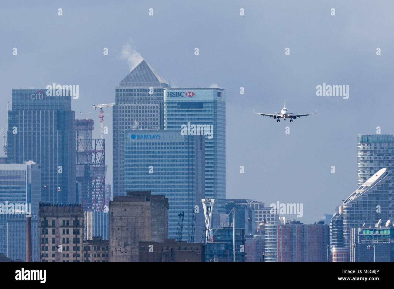 Atterrissage en avion à l'aéroport de London City avec les gratte-ciel de Canary Wharf en arrière-plan, Londres Angleterre Royaume-Uni Banque D'Images