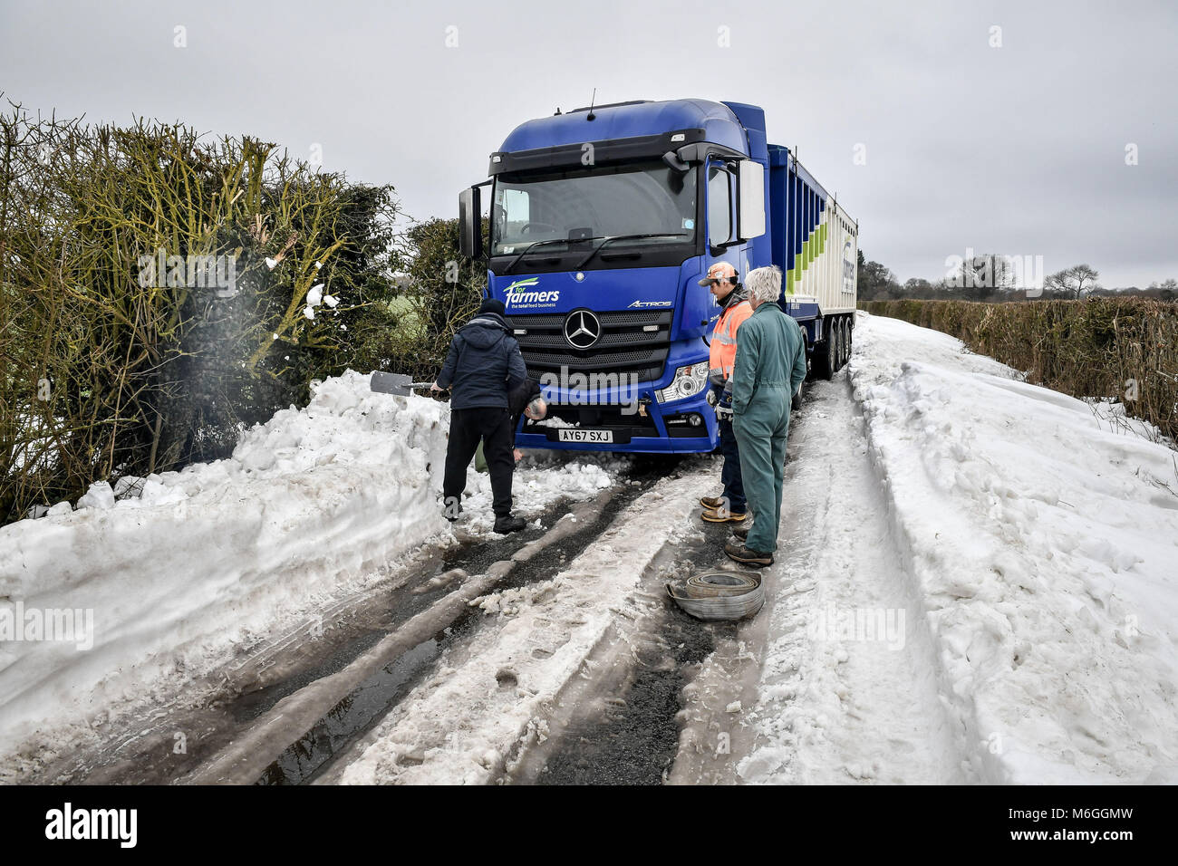Les hommes utilisent des pelles pour essayer gratuitement un camion coincé dans la neige sur Draycott près, entre Draycot Foliat et Ogbourne St George, près de Marlborough, Wiltshire, où la route est utilisé comme un détournement en raison de l'A346 reste par la neige. Banque D'Images