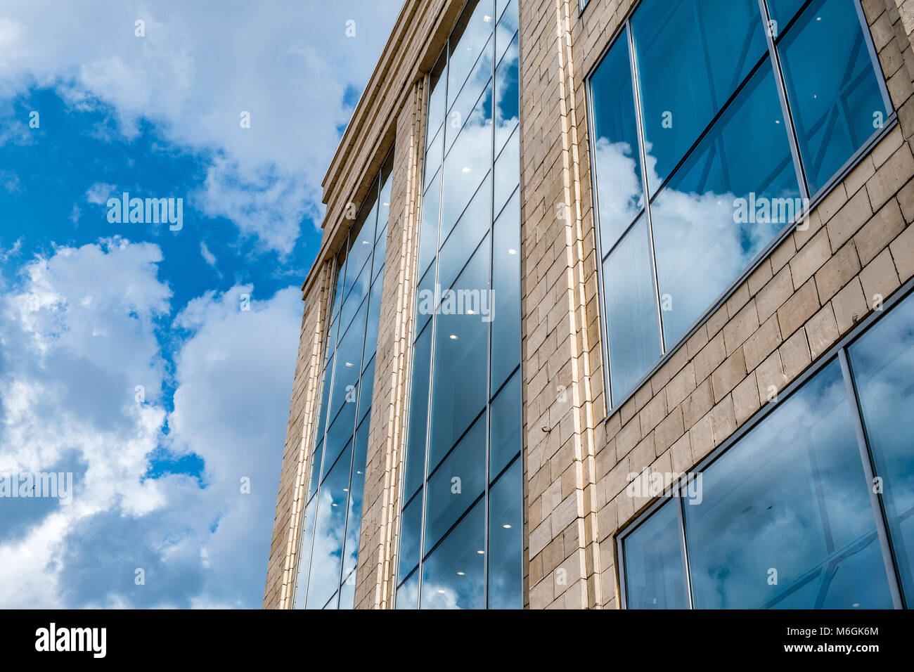 Réflexion des nuages dans le vitrage de façade d'un bâtiment moderne Banque D'Images