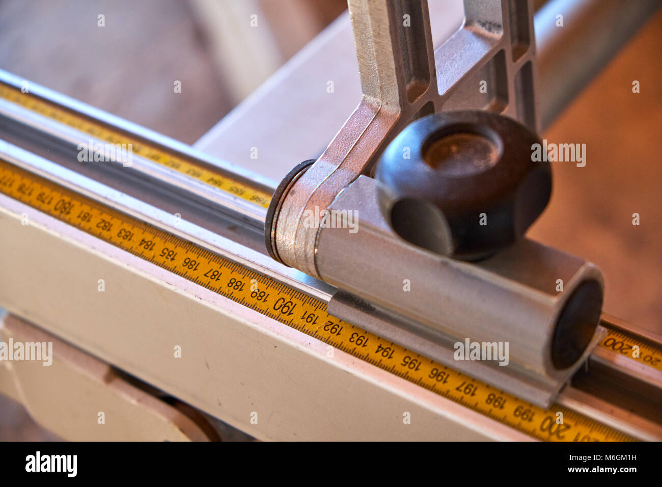 Règle en acier métrique de scie à table avec bloc d'arrêt en gros plan en atelier Banque D'Images