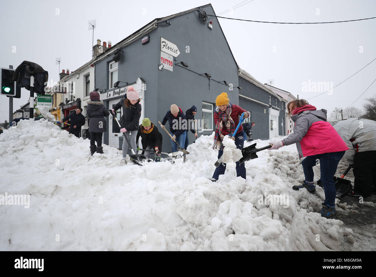 Les habitants participent à l'assainissement dans la ville de Sallins, Co Kildare après les tempêtes de neige que le froid continue à travers le pays. Banque D'Images