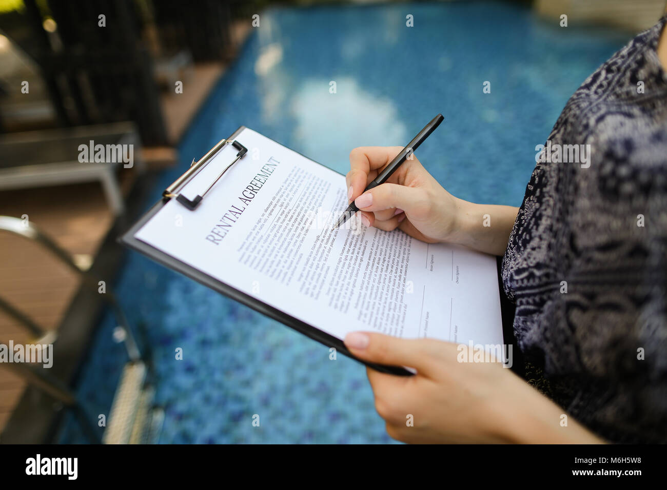 Close-up of hand of young woman signing document sur contexte o Banque D'Images
