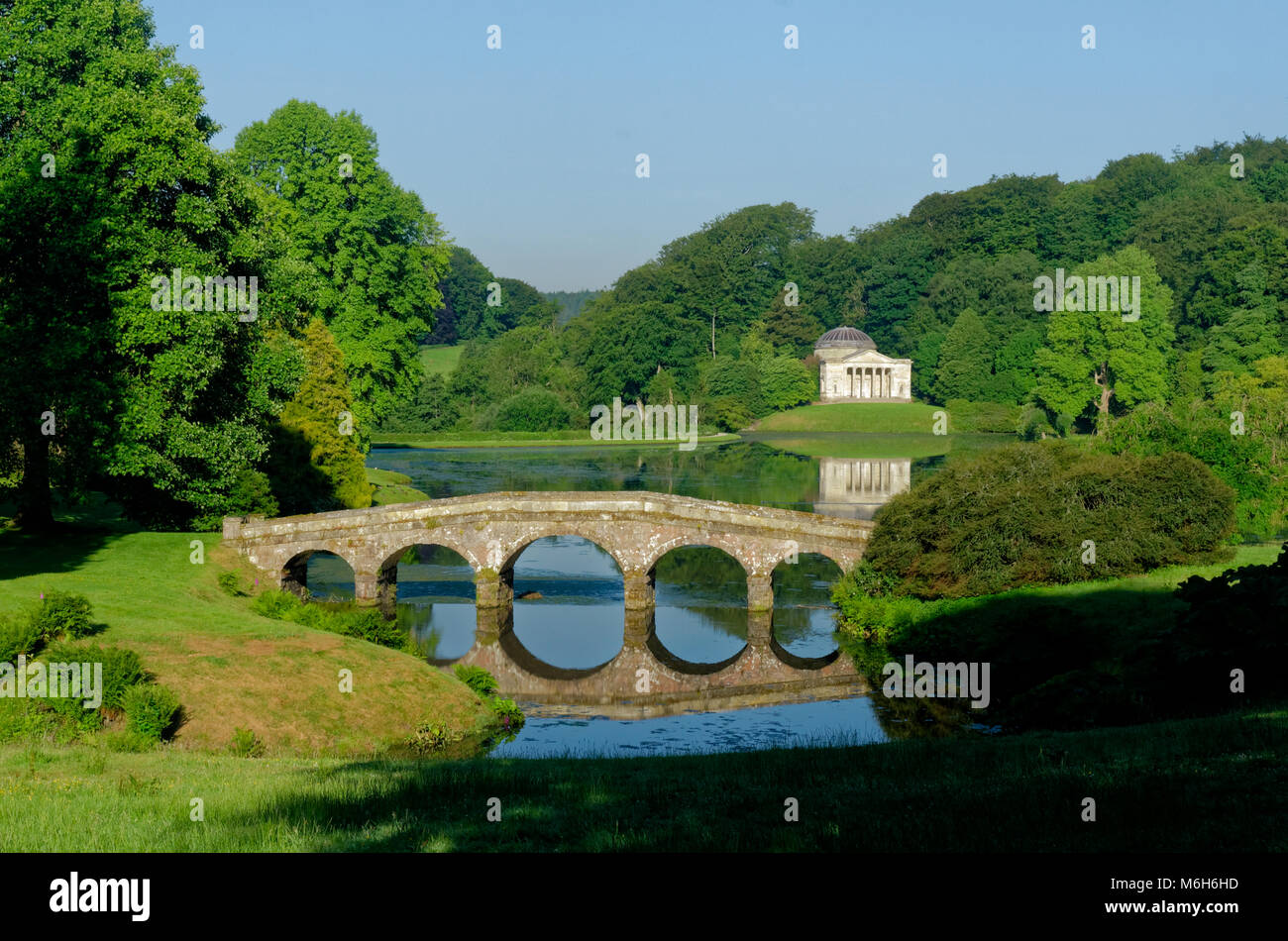 Le pont palladien et panthéon et leurs reflets dans le lac à Stourhead Garden Banque D'Images