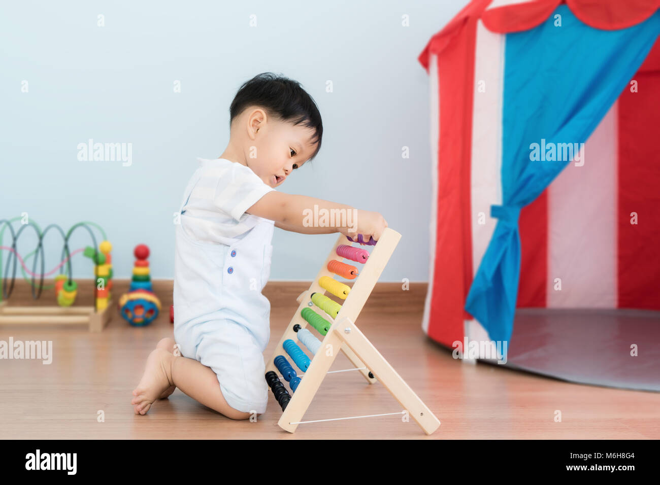Bébé garçon asiatique apprend à compter. Mignon enfant jouant avec abacus jouet. Petit garçon s'amusant à l'intérieur à la maison. Concept éducatif pour bébé. Banque D'Images