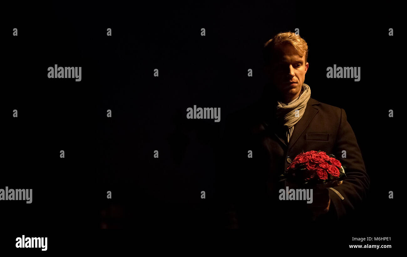 L'homme bouleversé holding Flowers, attendant en vain pour l'amie, crise relation Banque D'Images