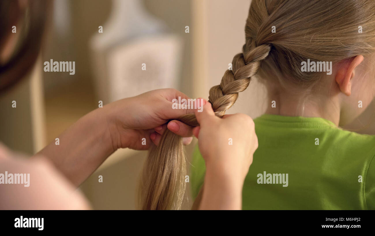 Femme de coiffure tressage, petite fille, la pédiculose du cuir chevelu et des cheveux, Banque D'Images