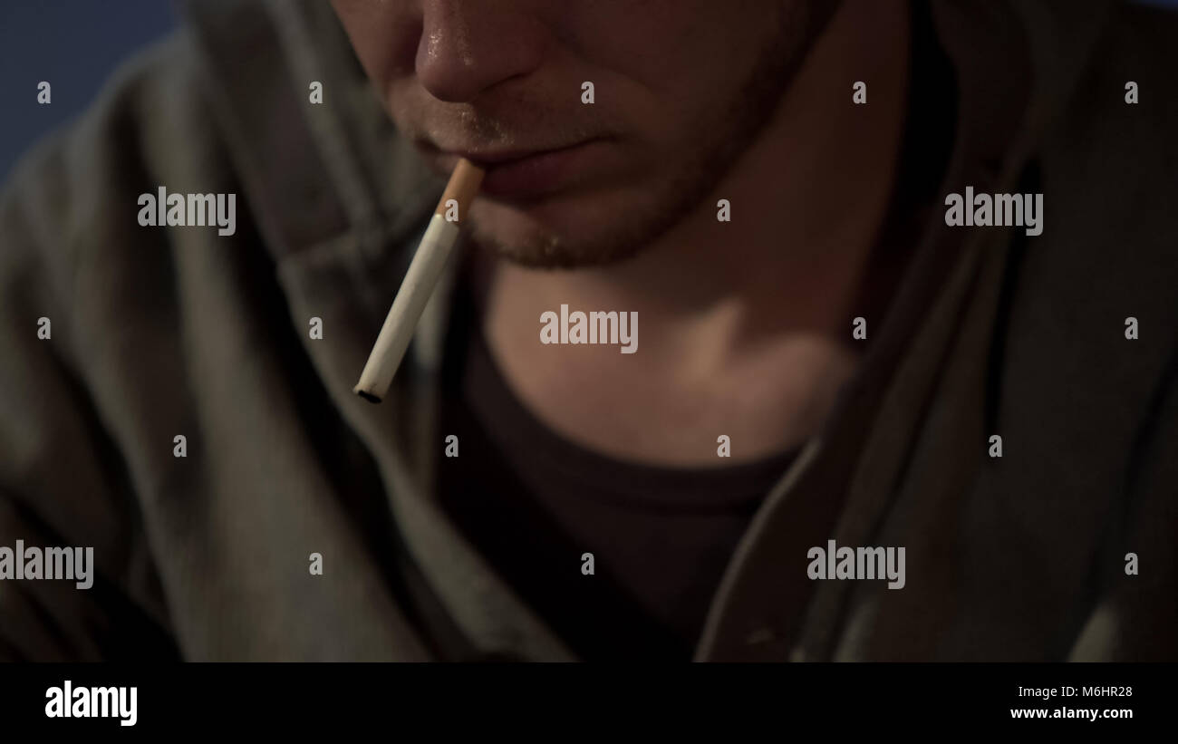 Jeune homme fume cigarette, déprimé et abandonnés, les risques pour la santé, Close up Banque D'Images