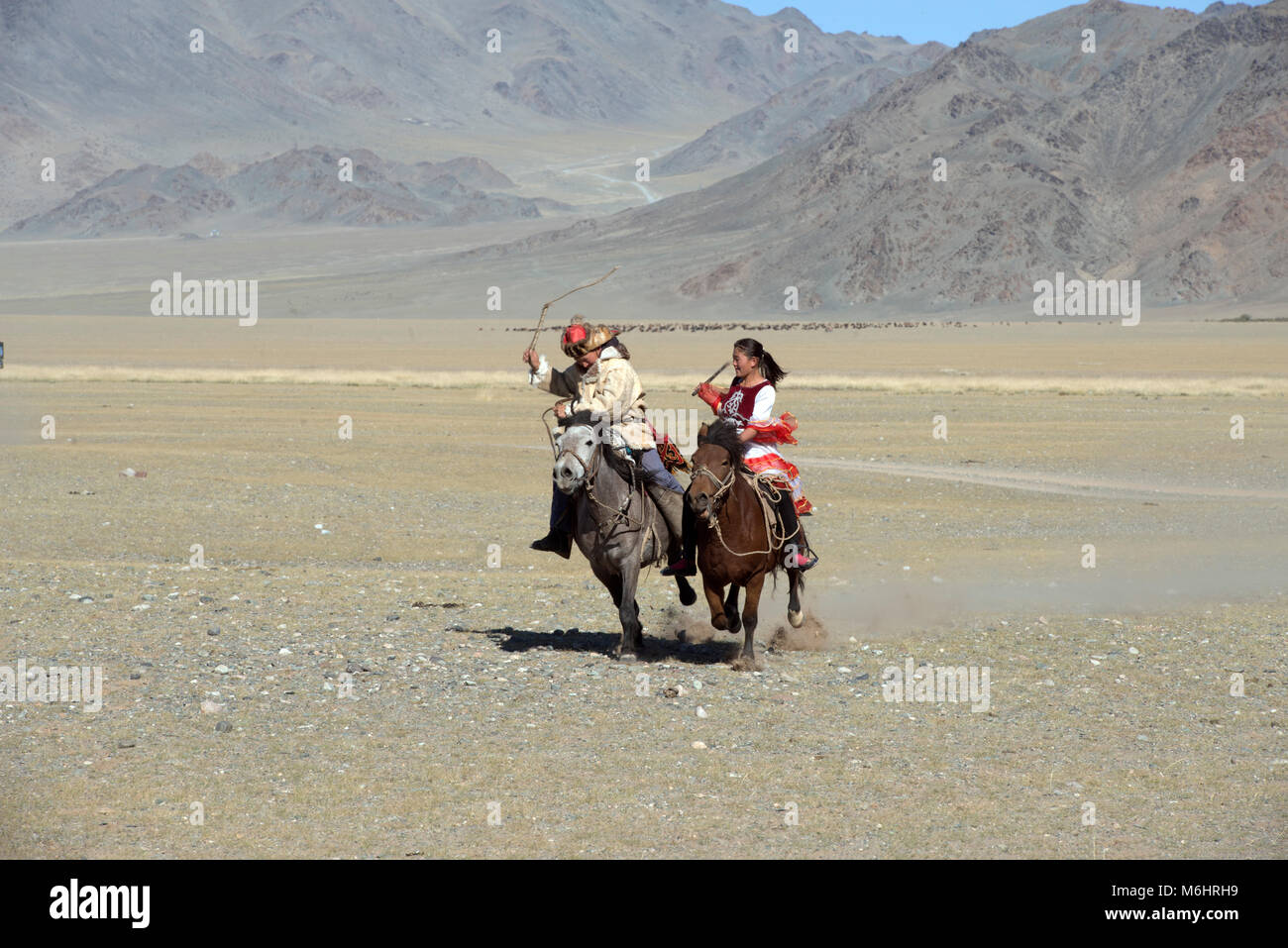 Une femme Kazakh whips son mari pendant le jeu de 'Kiss the girl' ('kiss femme à cheval' ou qyz quar) au 2017 Sagsai festival golden eagle. Banque D'Images