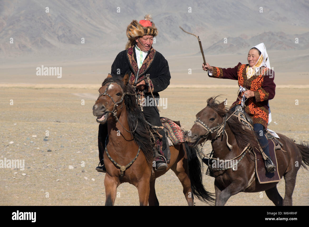 Une femme Kazakh whips son mari pendant le jeu de 'Kiss the girl' ('kiss femme à cheval' ou qyz quar) au 2017 Sagsai festival golden eagle. Banque D'Images