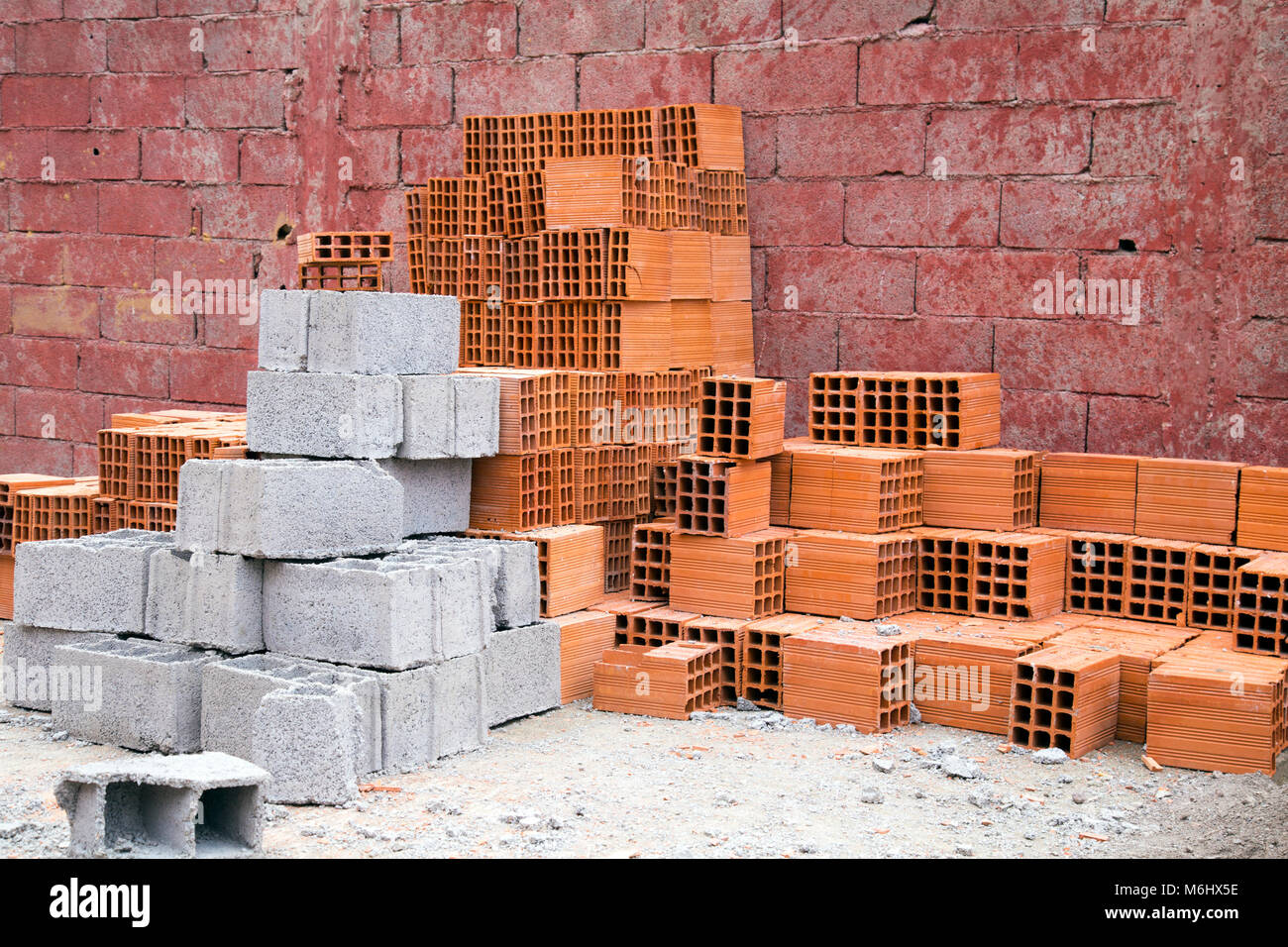 Des piles de briques rouges et gris sur un chantier Banque D'Images